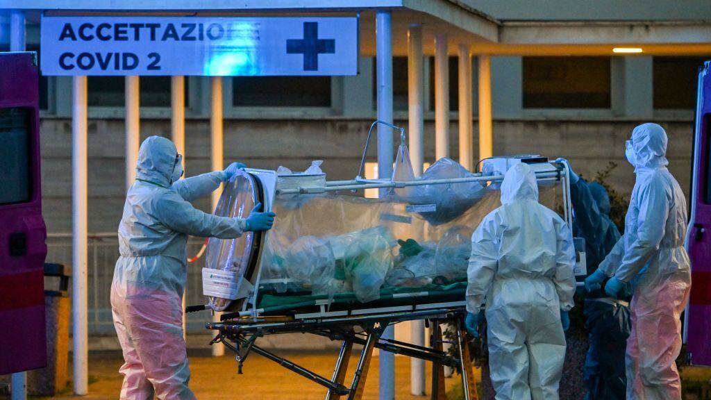 Medical workers in overalls stretch a patient under intensive care into the newly built Columbus Covid 2 temporary hospital to fight the new coronavirus infection, on March 16, 2020 at the Gemelli hospital in Rome. (Photo by ANDREAS SOLARO / AFP) (Photo by ANDREAS SOLARO/AFP via Getty Images)