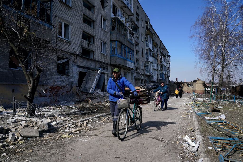 MARIUPOL, UKRAINE - MARCH 21: People walk past damaged buildings as civilians are evacuated along humanitarian corridors from the Ukrainian city of Mariupol under the control of Russian military and pro-Russian separatists, on March 21, 2022. (Photo by Stringer/Anadolu Agency via Getty Images)