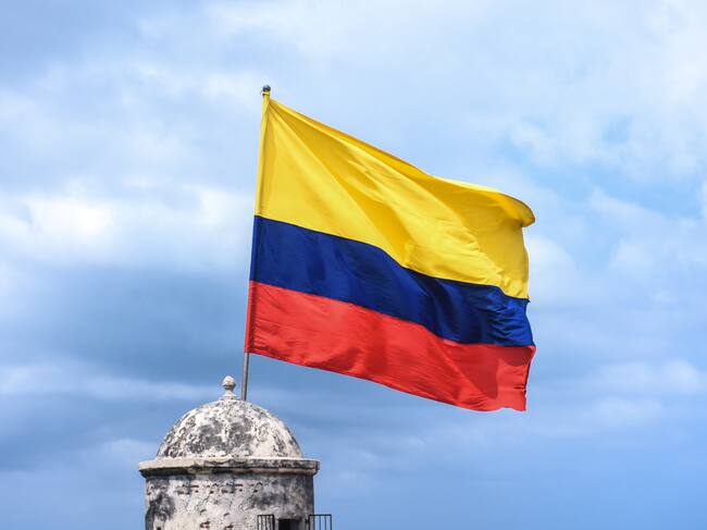 La bandera colombiana ondea sobre un edificio histórico