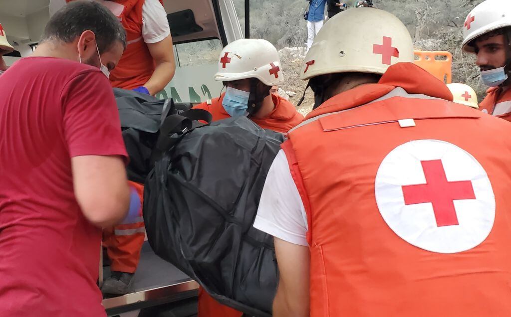 Paramédicos de la Cruz Roja llevan el cuerpo de una persona asesinada tras el bombardeo de Israel sobre el norte del Líbano