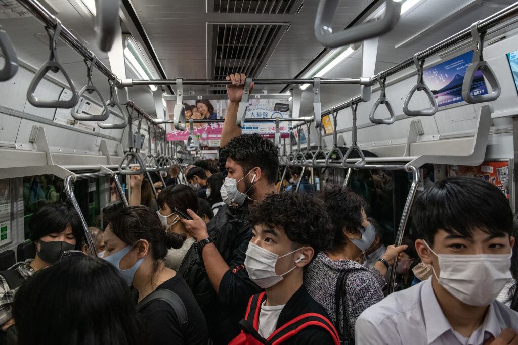 Personas agrupadas al interior de un tren en Tokio