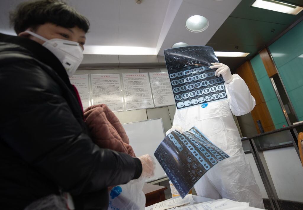 Un médico revisa a una paciente en un centro de aislamiento en China