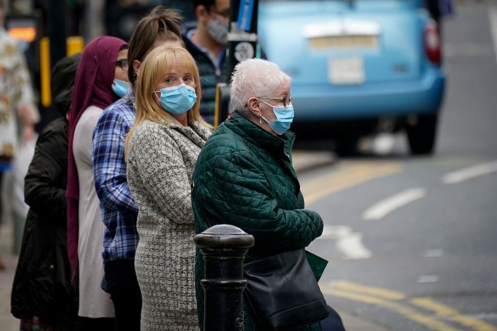 Personas usan mascarillas por el Covid-19 en Manchester