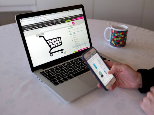 MADRID, SPAIN - JANUARY 03: A person shops with their mobile phone and computer on the day the online sales begin, on January 3, 2022, in Madrid, Spain. The January and February sales season will see a 7.5% increase in hiring, driven by traditional commerce but, above all, by e-commerce, due to new consumer preferences and the uncertainty of the sixth wave of coronavirus. Contracts will increase from 164,055 signed in 2021 to more than 176,000 expected in 2022. (Photo By Alberto Ortega/Europa Press via Getty Images)