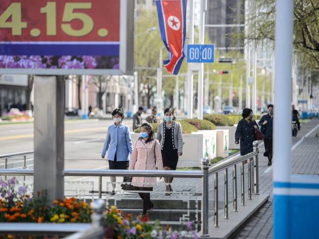Personas con mascarillas caminan hacia el metro en Pyonyang