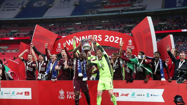 LONDON, ENGLAND - MAY 15: Wes Morgan and Kasper Schmeichel of Leicester City lift the Emirates FA Cup Trophy, following their team's victory in The Emirates FA Cup Final match between Chelsea and Leicester City at Wembley Stadium on May 15, 2021 in London, England. A limited number of around 21,000 fans, subject to a negative lateral flow test, will be allowed inside Wembley Stadium to watch this year's FA Cup Final as part of a pilot event to trial the return of large crowds to UK venues. (Photo by Marc Atkins/Getty Images)