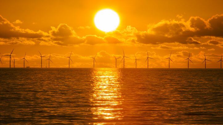 Sunset over the Walney offshore Wind farm from Walney island showing both the wind turbines and a gas platform further out in Morecambe Bay. The windfarm will shortly be the largest offshore wind farm in the world and currently generates 367 MW.