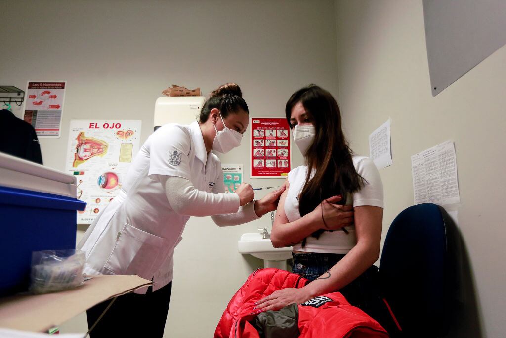 Trabajadora de la salud coloca una vacuna en Querétaro