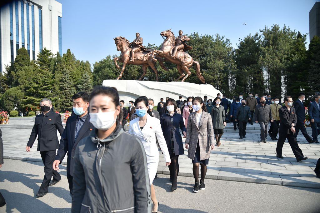 Las personas caminan con mascarillas luego de un acto en Pyongyang