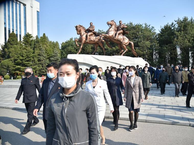 Las personas caminan con mascarillas luego de un acto en Pyongyang