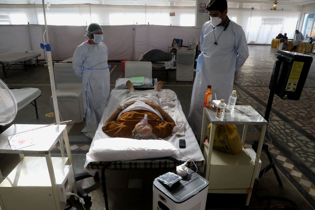 Trabajadores de la salud asisten a contagiada del Covid-19 en Nueva Delhi