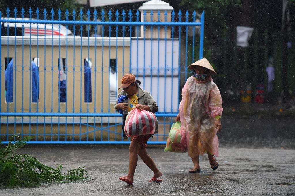 Dos personas salen con sus cosas en una ciudad de Vietnam