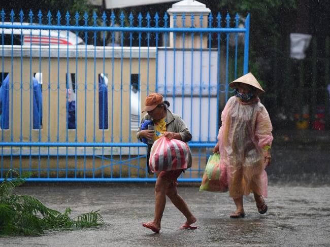 Dos personas salen con sus cosas en una ciudad de Vietnam