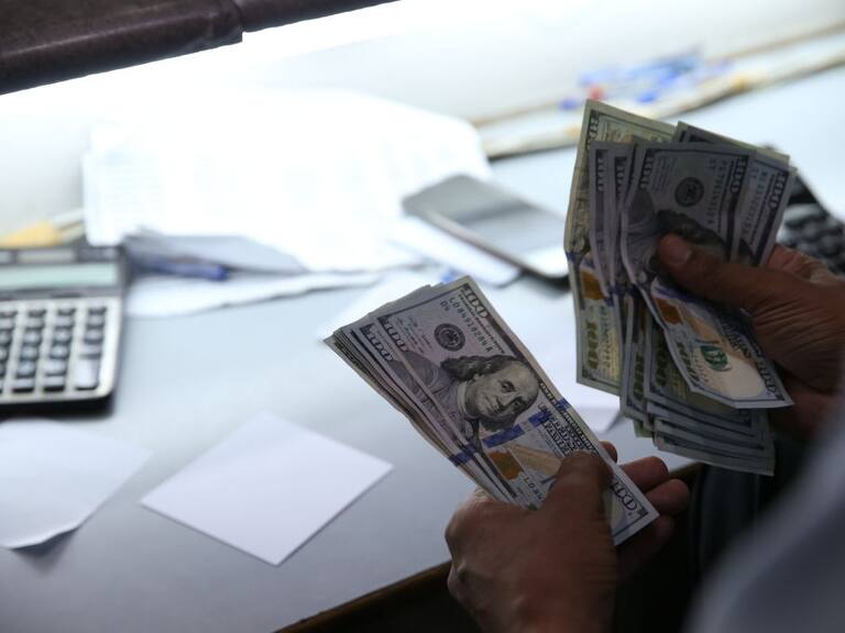Una persona cuenta dólares en una casa de cambio en Pakistán