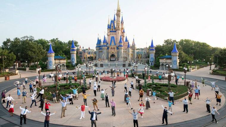 LAKE BUENA VISTA, FL - JULY 11: In this handout photo provided by Walt Disney World Resort, Josh DAmaro, chairman of Disney Parks, Experiences and Products (center front right) and Jeff Vahle, president of Walt Disney World Resort (center front left), pose with Disney cast members for a photo in front of Cinderella Castle prior to the phased reopening of Magic Kingdom Park at Walt Disney World Resort on July 11, 2020 in Lake Buena Vista, Florida. (Photo by David Roark/Walt Disney World Resort via Getty Images)