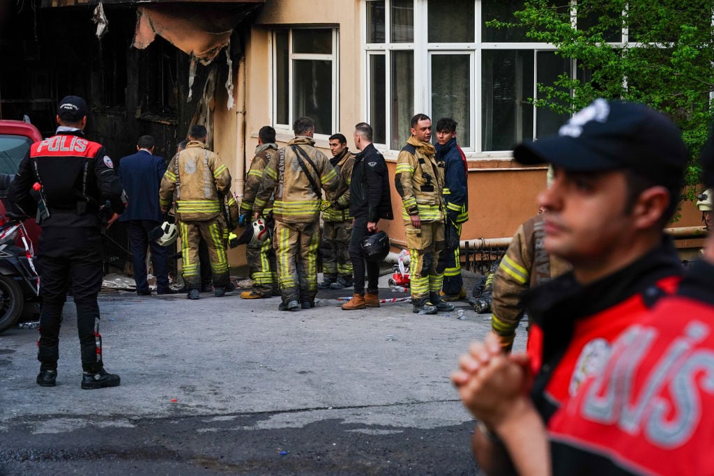 Los voluntarios de bomberos descansan tras apagar el incendio que quemó un centro nocturno en la ciudad de Estambul en Turquía.
