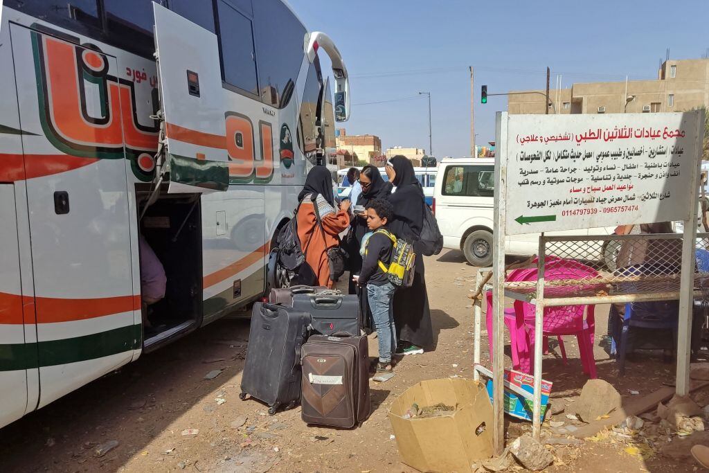 Habitantes de Sudán abordan buses para escapar del conflicto