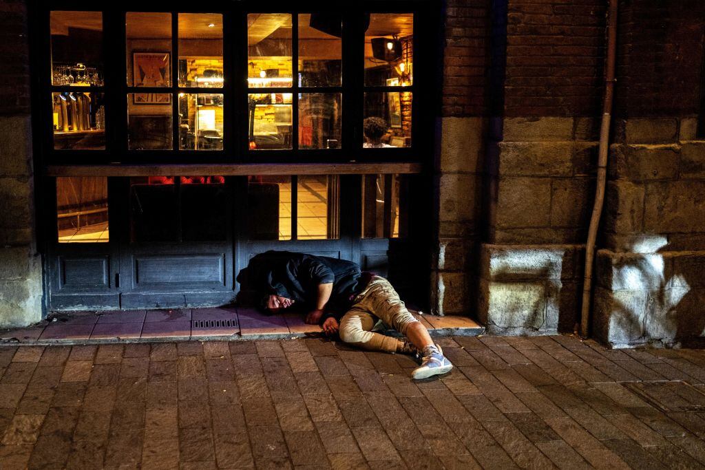 Un hombre duerme en la calle afuera de un bar en Francia