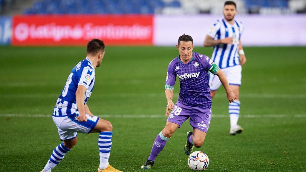 SAN SEBASTIAN, SPAIN - JANUARY 23: Andres Guardado of Real Betis runs with the ball under pressure from Andoni Gorosabel of Real Sociedad during the La Liga Santander match between Real Sociedad and Real Betis at Reale Arena on January 23, 2021 in San Sebastian, Spain. Sporting stadiums around Spain remain under strict restrictions due to the Coronavirus Pandemic as Government social distancing laws prohibit fans inside venues resulting in games being played behind closed doors. (Photo by Alex Caparros/Getty Images)
