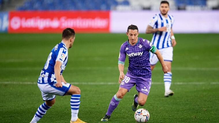 SAN SEBASTIAN, SPAIN - JANUARY 23: Andres Guardado of Real Betis runs with the ball under pressure from Andoni Gorosabel of Real Sociedad during the La Liga Santander match between Real Sociedad and Real Betis at Reale Arena on January 23, 2021 in San Sebastian, Spain. Sporting stadiums around Spain remain under strict restrictions due to the Coronavirus Pandemic as Government social distancing laws prohibit fans inside venues resulting in games being played behind closed doors. (Photo by Alex Caparros/Getty Images)