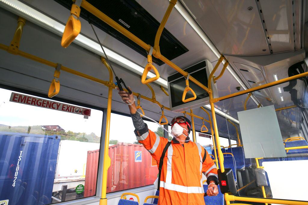 Un trabajador desinfecta un bus del transporte público en Nueva Zelanda