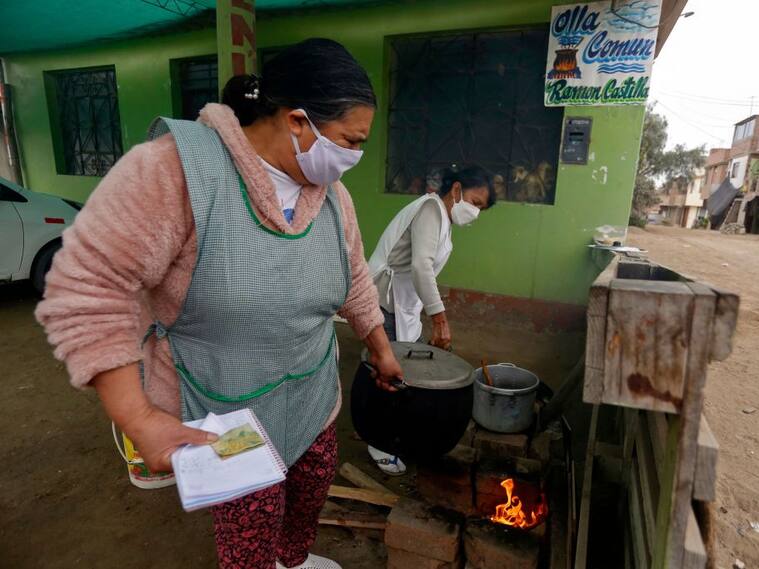 Mujeres preparan la comida en olla común de un barrio popular de Perú