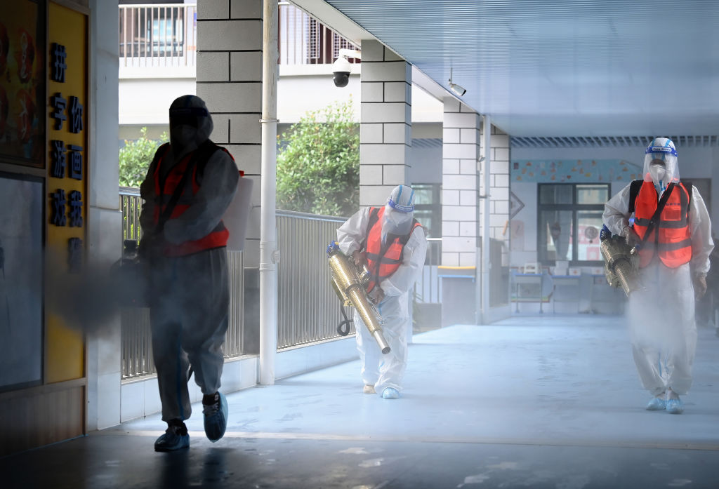 Trabajadores desinfectan una escuela básica en Wuhan