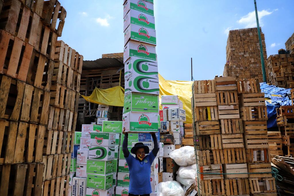 Trabajador lleva cajas en México