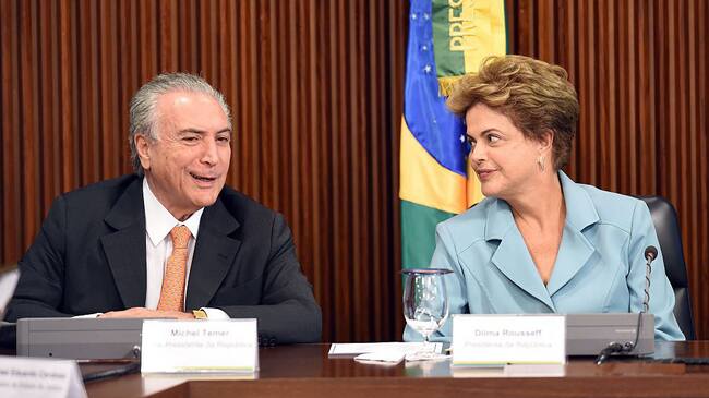 Brazilian President Dilma Rousseff (R) gestures next her Vice President Michel Temer, during a ministerial meeting at the Planalto Palace in Brasilia, on October 8, 2015. Rousseff claims to detect a glimmer at the end of the tunnel in Brazil's political crisis, but what she really may be seeing, analysts say, are the headlights of an oncoming train. AFP PHOTO/EVARISTO SA (Photo credit should read EVARISTO SA/AFP via Getty Images)
