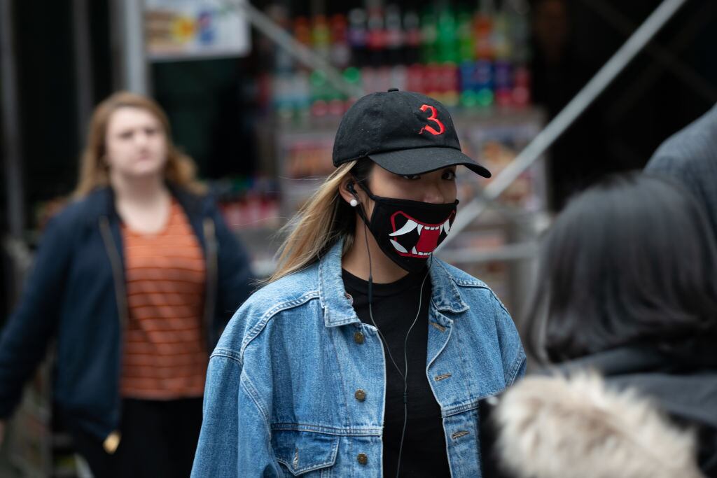 Una mujer utiliza una mascarilla en los alrededores de Time Square en la ciudad de Nueva York