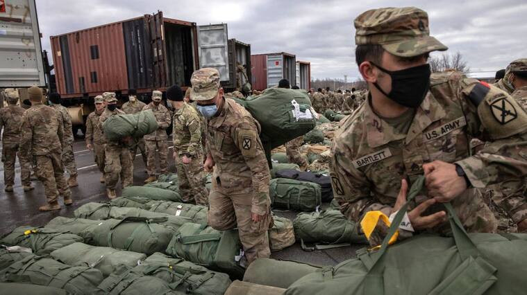 FORT DRUM, NEW YORK - DECEMBER 10: U.S. Army soldiers retrieve their duffel bags after they returned home from a 9-month deployment to Afghanistan on December 10, 2020 at Fort Drum, New York. The 10th Mountain Division soldiers who arrived this week are under orders to isolate with family at home or with fellow troops in barracks, finishing their quarantine just before Christmas. In the waning days of the Trump Administration and after 19 years of war, the U.S. military continues to reduce troop levels in Afghanistan. (Photo by John Moore/Getty Images)
