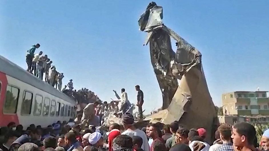 This screengrab provided by AFPTV shows people gathered around the wreckage of two trains that collided in the Tahta district of Sohag province, some 460 kms (285 miles) south of the Egyptian capital Cairo, reportedly killing at least 32 people and injuring scores of others, on March 26, 2021. - Egypt has been plagued with deadly train accidents in recent years that have been widely blamed on inadequate infrastructure and poor maintenance. (Photo by - / AFP) (Photo by -/AFP via Getty Images)