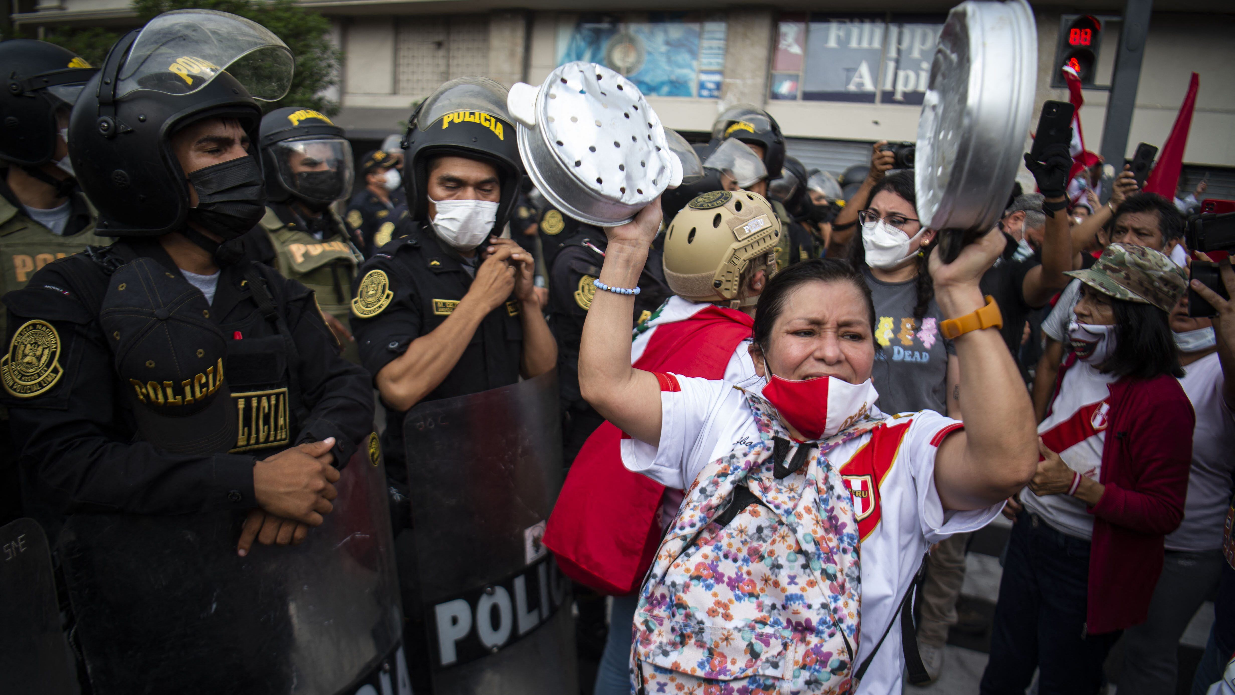 A woman bangs pans during a protest against the governement of Peru's President Pedro Castillo, in Lima on April 05, 2022 - Peruvian President Pedro Castillo announced the end of a curfew in the capital Lima aimed at containing protests against rising fuel prices following crisis talks with Congress. (Photo by ERNESTO BENAVIDES / AFP) (Photo by ERNESTO BENAVIDES/AFP via Getty Images)