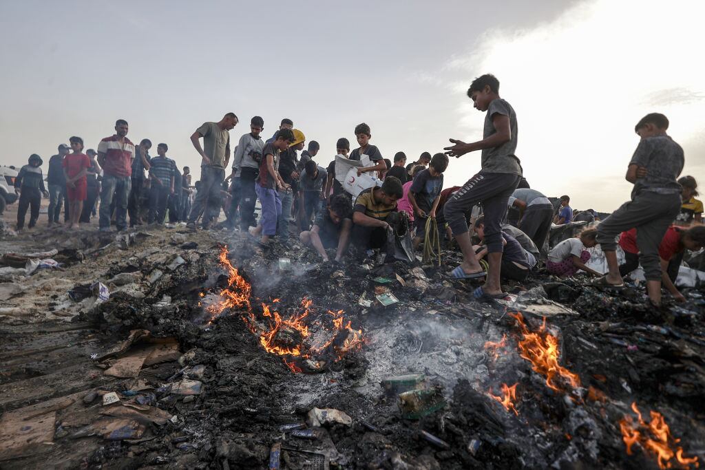 RAFAH, GAZA - MAY 27: Palestinians observe the destruction caused by the attacks of Israeli army on tents of displaced Palestinians living near the United Nations Relief and Works Agency for Palestine Refugees (UNRWA) warehouses in Rafah, Gaza on May 27, 2024. The attack killed at least 30 Palestinians including children according to Gaza media office. (Photo by Ali Jadallah/Anadolu via Getty Images)