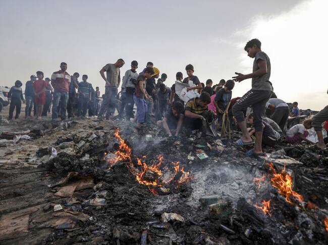 RAFAH, GAZA - MAY 27: Palestinians observe the destruction caused by the attacks of Israeli army on tents of displaced Palestinians living near the United Nations Relief and Works Agency for Palestine Refugees (UNRWA) warehouses in Rafah, Gaza on May 27, 2024. The attack killed at least 30 Palestinians including children according to Gaza media office. (Photo by Ali Jadallah/Anadolu via Getty Images)