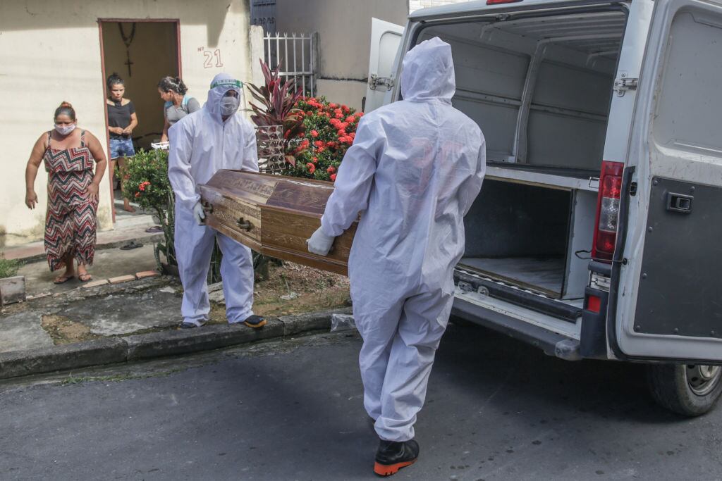 Trabajadores retiran a un fallecido por Covid-19 en Brasil