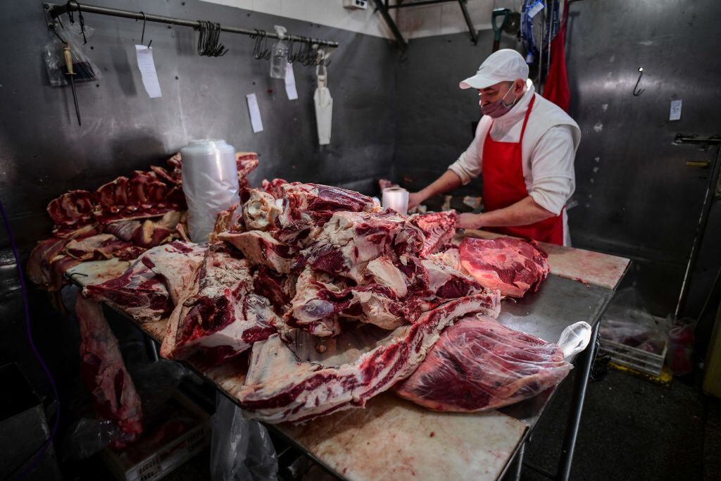 Un carnicero prepara los cortes de vacuno en el mercado de Liniers