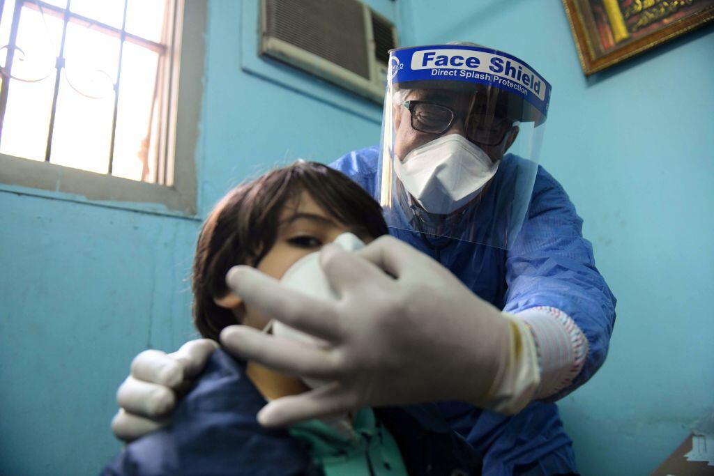 Médico atiende a un niño por la pandemia en Egipto