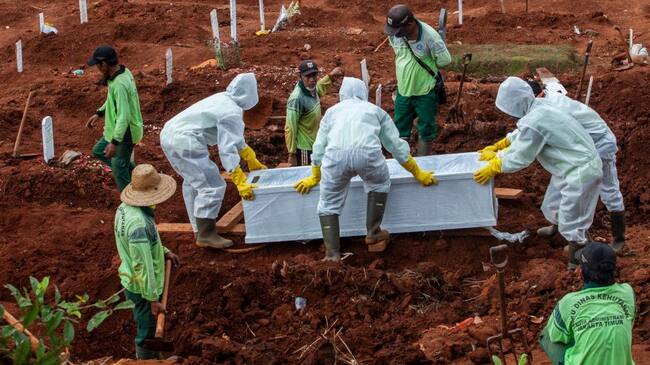 Trabajadores realizan el funeral de una víctima del Covid-19 en Indonesia