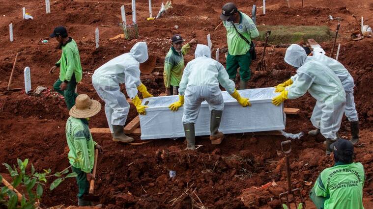 Trabajadores realizan el funeral de una víctima del Covid-19 en Indonesia