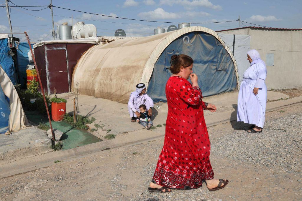 Personas caminan por un campo de refugiados iraquíes en la región kurda