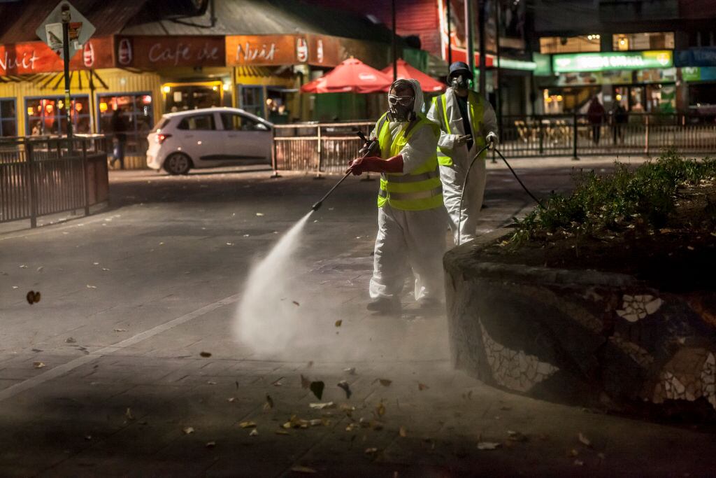 Workers of a cleaning company clean the streets of the city, in Osorno, Chile, on March 18, 2020.President Sebastian Pinera decreed a state of catastrophe throughout Chile for ninety days before the advance of Covid-19, this measure is in effect from 00:00 on Thursday, March 19. The President has the exceptional powers to restrict: the freedoms of locomotion and assembly; arrange requisitions of goods; establish limitations to the exercise of the property right; and, adopt all the extraordinary administrative measures that are necessary for the prompt restoration of normality in the affected area, in Osorno, Chile. (Photo by Fernando Lavoz/NurPhoto via Getty Images)