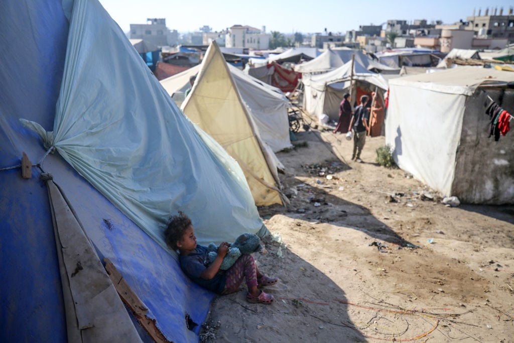 Un niño palestino desplazado sobrevive en un campamento en la Franja de Gaza, en medio de los ataques militares de Israel.