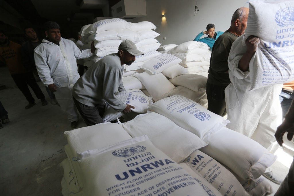 DEIR AL-BALAH, GAZA - MARCH 03: Palestinians flock to receive flour distributed by The United Nations Relief and Works Agency for Palestinian Refugees in the Near East (UNRWA) in Gaza, where there is a food crisis due to Israeli attacks in Deir Al-Balah, Gaza on March 03, 2024. A large number of Palestinians who wanted to benefit from the distributions crowded the distribution center in the city of Deir Belah. As the food crisis escalates in Gaza due to Israeli attacks, the United Nations Relief and Works Agency for Palestinian Refugees in the Near East (UNRWA) distribute essential flour supplies. (Photo by Ashraf Amra/Anadolu via Getty Images)