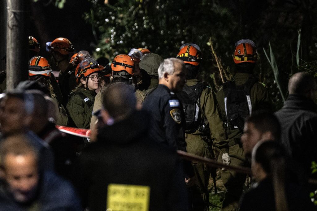 Los voluntarios de los equipos de emergencia se despliegan en Tel Aviv luego que un proyectil impactara esa ciudad del centro de Israel