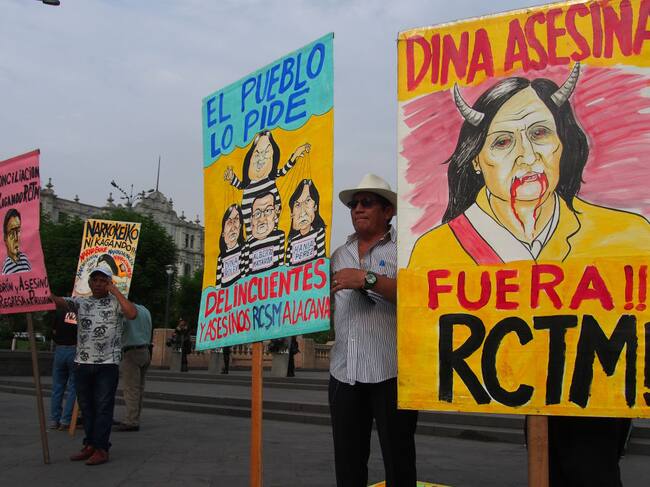 En el Perú unas personas portan carteles en la ciudad de Lima en contra de la presidenta interina Dina Boluarte y la acusan de violaciones a los DDHH.