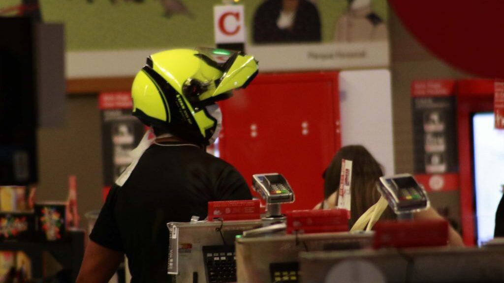 25 MARZO 2020 / SANTIAGOUn joven con casco de moto y mascarilla pagando en las cajas, durante las compras realizadas en Unimac ubicado en Av. Vitacura 4607, por la cuarentena  total por 7 días, impuesta por el gobierno debido la emergencia sanitaria que ha provocado el Coronavirus COVID-19 en todo el país 
FOTO: MAURICIO MENDEZ /AGENCIAUNO