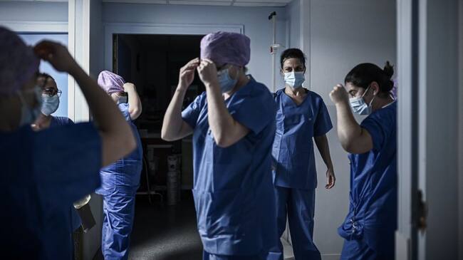 In this picture taken on December 3, 2020, medical health workers get ready for their night shift at the Covid-19 care unit of the Polyclinique Jean Villar private hospital part of the Elsan group, in Bruges, southeastern France. - Vaccination against Covid-19 will be free for all, French Prime Minister Jean Castex announced on December 3, 2020, adding that the government has budgeted for this purpose 1,5 billion euros in the social security budget for 2021. (Photo by Philippe LOPEZ / AFP) (Photo by PHILIPPE LOPEZ/AFP via Getty Images)