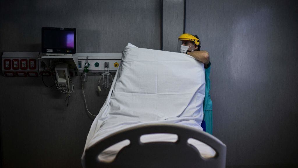 A health worker prepares a bed for a new patient at the Intensive Care Unit of the El Cruce - Dr Nestor Kirchner hospital in Florencio Varela, Argentina on April 13, 2021. - Latin America suffers a new upsurge of the covid-19 pandemic with records in contagions in Argentina and Uruguay, as worldwide immunisation campaigns will be affected in the United States and South Africa by the suspension of the Johnson &amp; Johnson vaccine, which will also delay itrs distribution in Europe. (Photo by RONALDO SCHEMIDT / AFP) (Photo by RONALDO SCHEMIDT/AFP via Getty Images)