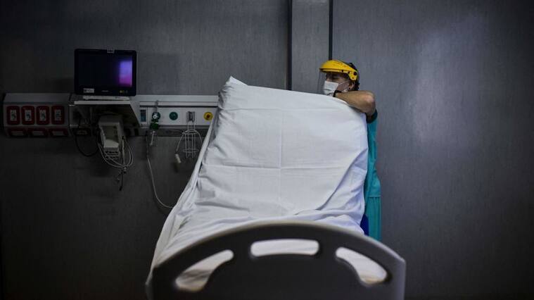 A health worker prepares a bed for a new patient at the Intensive Care Unit of the El Cruce - Dr Nestor Kirchner hospital in Florencio Varela, Argentina on April 13, 2021. - Latin America suffers a new upsurge of the covid-19 pandemic with records in contagions in Argentina and Uruguay, as worldwide immunisation campaigns will be affected in the United States and South Africa by the suspension of the Johnson & Johnson vaccine, which will also delay itrs distribution in Europe. (Photo by RONALDO SCHEMIDT / AFP) (Photo by RONALDO SCHEMIDT/AFP via Getty Images)